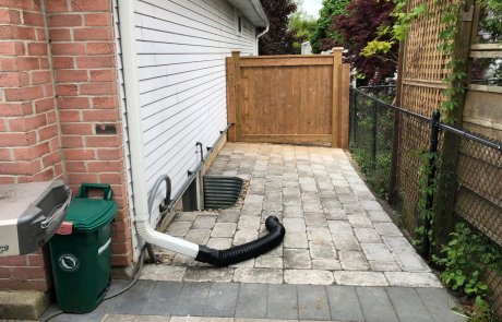 New side walkway storage area with unilock interlocking stone and wood privacy fence